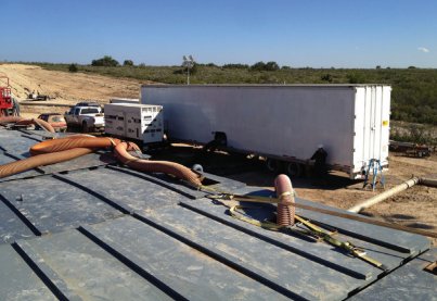 UVX unit treating dark oilfield water straight from a lined pit